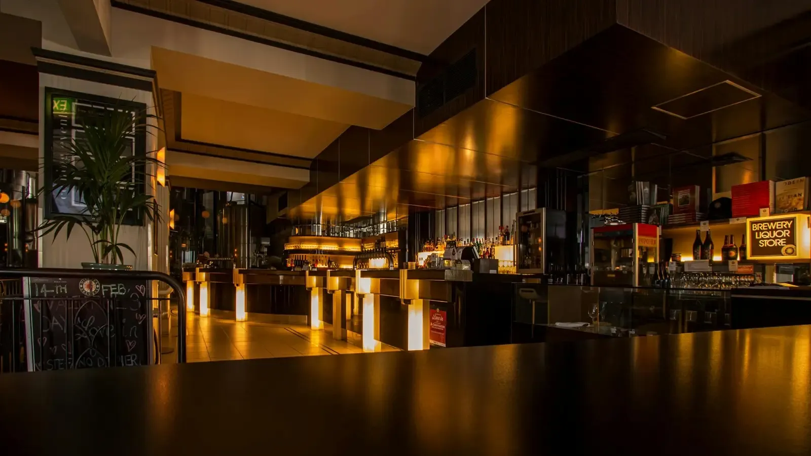 Dimly lit restaurant and bar floor set for evening service