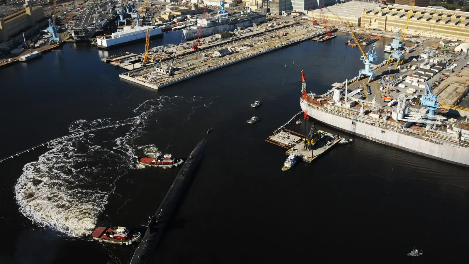 Aerial view of a US Navy submarine departing Norfolk Naval Shipyard in Portsmouth, Virginia